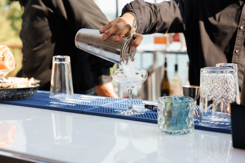 bartender-pouring-cocktail-in-portable-bar